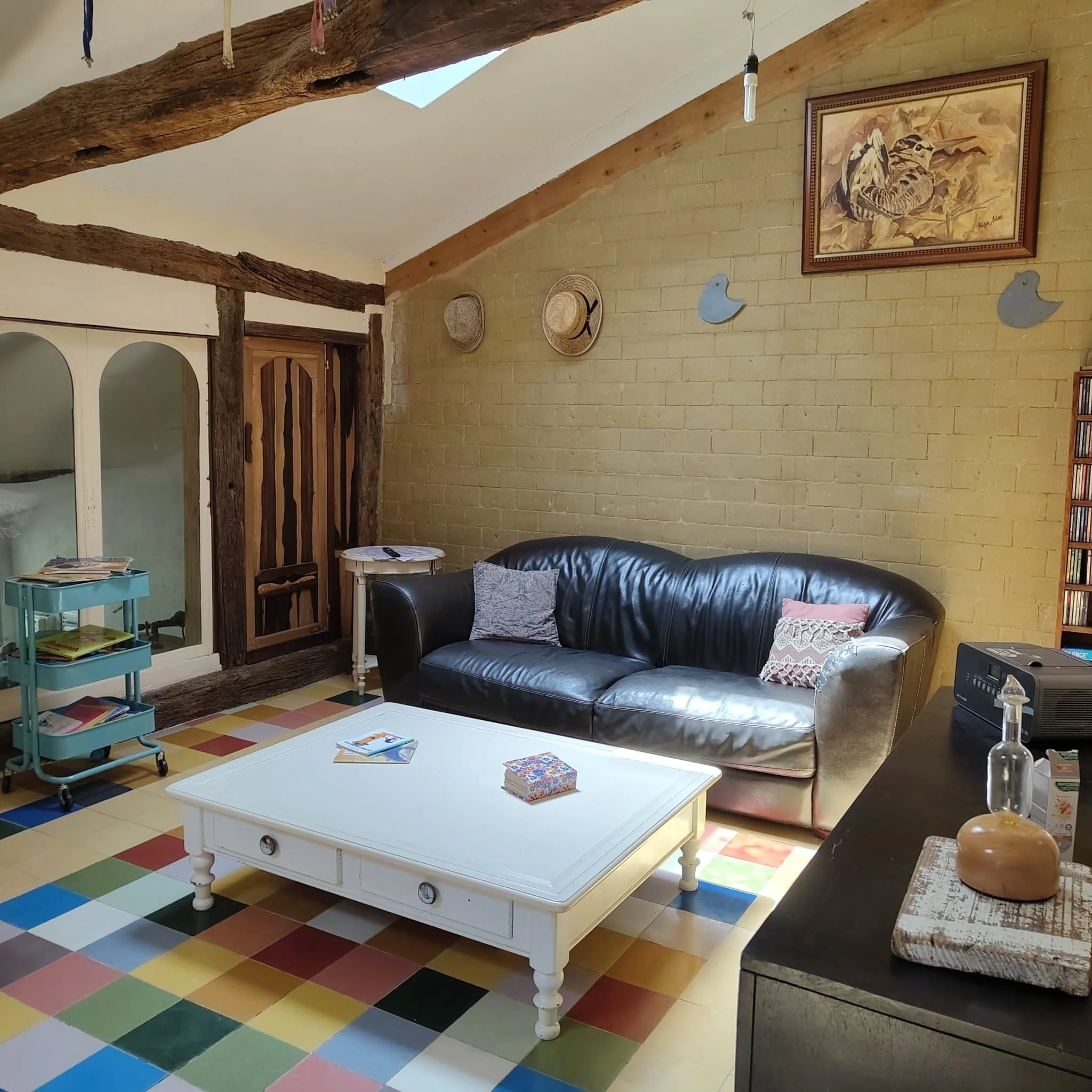 Lounge with old beams, skylight and colourful floor
