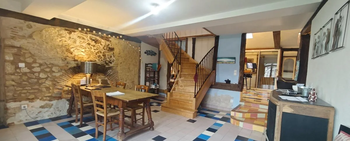 Main living and dining room with table, fireplace and staircase